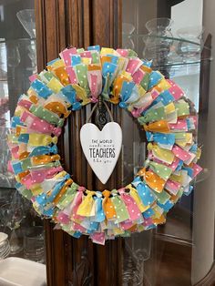 a colorful wreath with the words teachers hanging from it's front door frame