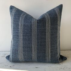 a blue and white striped pillow sitting on top of a table