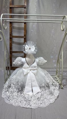 a white teddy bear sitting on top of a table next to a metal rack and chair