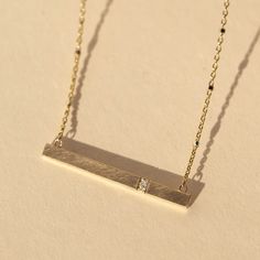 The 14k gold GNAR necklace features a slender bar with our signature satin finish and 2 offset white diamonds. Chain is attached. A perfect layering addition to the CHAI, GORP and GORY necklaces. Chain is 14k gold 1.0mm ice cube sparkle chain Necklace length is 16" Full cut round white diamonds, approximately .014 ctw Horizontal bar is approximately 30mm x 3mm Designed and hand forged in our studio in coastal Southern California Complimentary ShippingReturns and Exchanges 14k Gold Bar Necklace, California Colors, Gold Bar Necklace, Necklace Chain Lengths, Color Swatch, Gold Bar, Rose Gold Necklace, White Diamonds, Bar Necklace