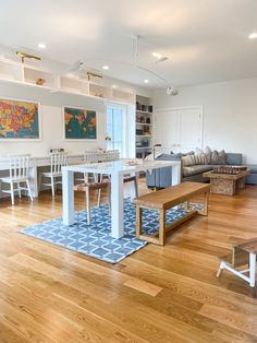 a living room filled with lots of furniture and a large wooden table in the middle