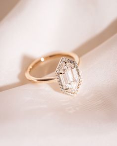 a diamond ring sitting on top of a white cloth