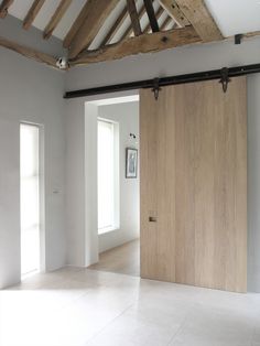 an image of a white room with wooden doors and beams on the ceiling is featured in this article