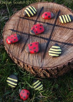 four red and white buttons sitting on top of a piece of wood in the grass