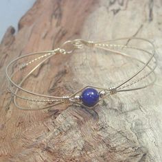 A sweet design of three strands of 14kt gold filled wire featuring a single 6mm genuine lapis bead flanked by two small 14kt gold filled beads. So delicate and feminine! It's likely that you have several blue outfits in your closet. Blue is the most cited favorite color of all! This stylish, well-fitting bangle will go with them all, and is sure to get noticed every time you wear it! The sturdy built-in hook and eye clasp is easy to get on and off by yourself. Choose your perfect size from the v Resizable Gold Wrap Bracelet As Gift, Adjustable Hand-strung Wrap Bangle, Gold Hand-strung Wrap Bracelet Gift, Friendship Hand Wrapped Bangle Bracelet, Dainty Adjustable Wire Wrapped Beaded Bracelets, Hand-strung Friendship Bracelet Jewelry, Hand-strung Friendship Bracelet, Elegant Beaded Wrap Bracelet As Gift, Elegant Adjustable Wrap Bracelet For Gift