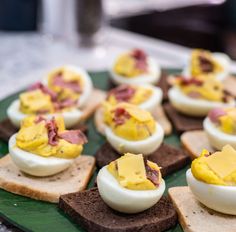 deviled eggs with ham and cheese are on bread slices for an appetizer