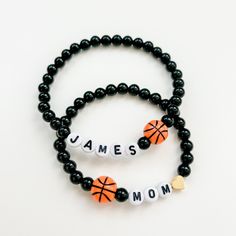 two bracelets with black beads and orange basketball balls on them that say, james mom