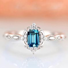 an engagement ring with a blue stone in the center and diamond accents around the band