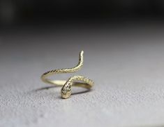 9k solid gold adjustable snake ring , made from recycled gold. Delicate and unique , The ring has been made in wax and then casted in 9k solid gold. Also available with Ruby gemstone : https://cyklu.etsy.com/listing/1575385029 MATERIAL- 9k gold Every piece you purchase from Cyklu is unique and handmade with love and affection, please allow one week after payment  ELSEWHERE - Instagram: instagram.com/CYKLU_JEWELRY -Pinterest: pinterest.com/Cyclu -Twitter: twitter.com/Cyklu - Facebook: Facebook.com/CykluJewelry Dainty Gold Ring, Ring Wrap, Dainty Gold Rings, Snake Ring, Gold Snake, Ring Dainty, Insta Instagram, Ruby Gemstone, Recycled Gold