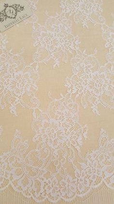 an image of white lace fabric on a tablecloth with a tag in the middle