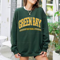 "Get ready for Green Bay football with this vintage-style, varsity sweatshirt. This crewneck has a retro design for your game day.  - These are Unisex fit. Please check sizing if you would like to order up 1-2 sizes for an oversized sweatshirt. * Packaged and Shipped in the USA! ---UNISEX SWEATSHIRTS--- - Specially spun cotton/poly, 50/50 - Medium-heavy soft fabric - Classic fit - Tear-away label - Runs true to size ---SIZES--- Small - 20\" W | 27\" L Medium - 22\" W | 28\" L Large - 24\" W | 29\" L XLarge - 26\" W | 30\" L 2XLarge - 28\" W | 31\" L 3XLarge - 30\" W | 32\" L 4XLarge - 32\" W | 33\" L ---CARE INSTRUCTIONS--- - Wash clothing inside out on cold setting - Tumble dry: low heat setting - Do not use bleach - Do not dry clean - Do not iron directly on design - Colors may look slig Oversized Tops For School Spirit In Fall, Oversized Tops For Fall With School Spirit, Collegiate Sweater For Game Day, Collegiate Long Sleeve Sweater For Game Day, Collegiate Team-colored Sweatshirt For Fall, Fall Fan Gear Long Sleeve Sweatshirt, Fall Long Sleeve College Style T-shirt, Collegiate Crew Sweatshirt For Fall, Long Sleeve Sweatshirt For Sports Events In Fall