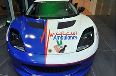 a blue and white sports car with arabic writing on the front hood is parked in a showroom