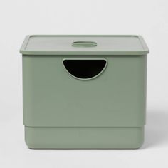 a green storage box with a hole in the middle and a lid on it's side