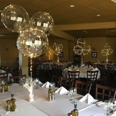 the tables are set with clear balloons and place settings