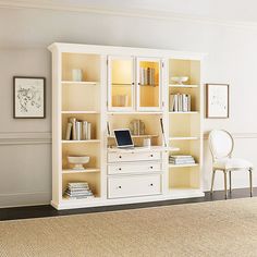 a room with a chair, desk and bookshelf on the floor in front of it