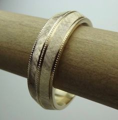 This bevel-edge  band is hand Florentine  all-round  approximately 6.5mm wide and weight is  approximately  10 to 11 grams of 14k yellow gold. The band is milgrain in the center and sides. Available in all finger sizes from 8 - 12.  Sizing outside of that range is a special order, contact for pricing and info.Each band is made to order and is a final sale.  If you need the band sooner than the listed processing time, we may able to do a rush order if our workload permits.We love this ring becaus Heirloom Yellow Gold Bands With Decorative Details, Gold Milgrain Round Band, Classic Jewelry With Diamond Cut And Thick Band, Gold Milgrain Bands For Anniversary, Fine Jewelry Wedding Rings With Milgrain Detail, Heirloom 14k Gold Wedding Band Thick Shape, Fine Jewelry Engraved Wide Band Wedding Ring, Formal Yellow Gold Bands With Milgrain, Yellow Gold Wedding Band With Decorative Detail