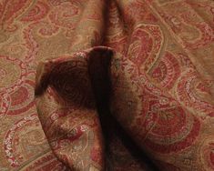 the fabric is red and gold with an intricate pattern on it's side,