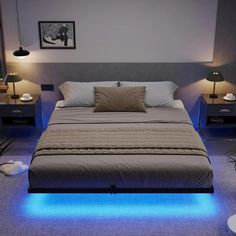 a bed with two lamps on either side of it and a blue light underneath the bed