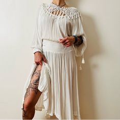 This Free People Dress Embodies Effortless Bohemian Elegance With Its Flowing Silhouette And Intricate Crochet Detailing. The Soft, Airy Fabric Allows For Movement And Comfort, Making It Perfect For Any Occasion Where You Want To Feel Both Stylish And Relaxed. The Off-White Color Adds A Timeless, Versatile Element To Your Wardrobe, Easily Paired With A Variety Of Accessories To Create A Personalized Look. The Dress Also Features Playful Tassels And A Smocked Waistband That Flatters The Figure Wh Bohemian Long Sleeve Beach Dress For Brunch, Bohemian Beach Cover-up Dress With Crochet Trim, Bohemian Dress With Flowy Skirt And Long Sleeves, Fitted Bohemian Dress For Brunch, Bohemian Spring Midi Dress With Lace Trim, Bohemian Fitted Midi Beach Dress, Bohemian Flowy Beach Dress For Brunch, Fitted Bohemian Beach Dress For Brunch, Bohemian Midi Dress With Crochet Trim For Summer