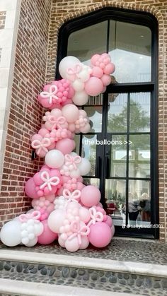 balloons are arranged in the shape of a tree on top of steps outside a building