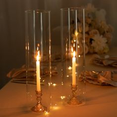 three tall candles are lit on a table