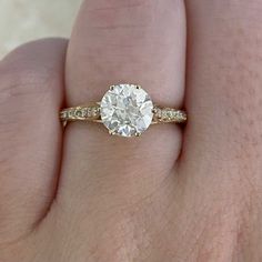 a woman's hand with a diamond ring on top of her finger and an engagement band