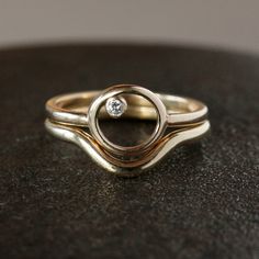 Made of solid 14k gold, this modern, minimalist wedding band is the perfect compliment to your engagement ring. A sweeping curve allows this ring to stack with a diamond ring that projects outwards at the center. The band measures 1.7mm thick and 2mm wide, and has a rounded profile. This ring is available in either 14k rose gold or 14k yellow gold. If you are at all unsure of the ring size, please purchase this easy, reusable finger sizer before you order the ring: https://www.etsy.com/listing/1 Modern Single Diamond Wedding Ring, Modern Stackable Rings With Tension Setting For Anniversary, Modern 14k Gold Stackable Rings With Round Cut, Modern Brilliant Cut Stackable Wedding Rings, Minimalist Curved Wedding Rings, Modern Stackable Diamond Rings For Weddings, Modern Diamond Ring With Tension Setting, Modern 14k Gold Stackable Rings For Anniversary, Modern Stackable Diamond Wedding Ring