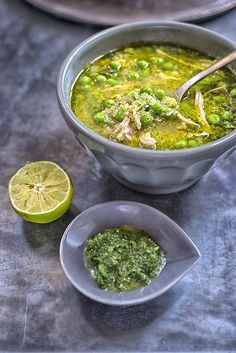 a bowl of soup with peas and limes