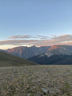 the mountains are covered in grass and trees