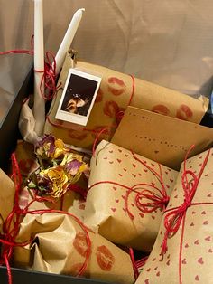 wrapped presents in a box with candles and pictures