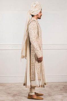 Ivory sherwani with all-over aari zardozi work paired with flared long kurta and churidar. Comes with safa, stole , kamarbandh and jutti fabric.
Components:7
Embroidered
Neckline:Mandarin Collar
Sleeve Length:Sherwani: Full
Fabric:Katan silk, Matka silk, Chanderi
Color:White
Side slits
Closure: Sherwani: Concealed front placket
Note: Brooch on the safa is not for sale - Aza Fashions Ivory Sherwani, Embroidered Sherwani, Zardozi Work, Tarun Tahiliani, Katan Silk, Embroidered Neckline, Churidar, Kurta Set, Embroidered Silk