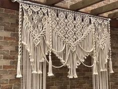 macrame curtains hanging on the side of a brick wall