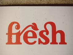 a sign that says fresh on the side of a building with water drops all over it