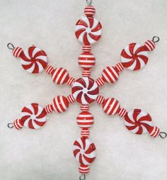 a red and white ornament with candy canes hanging from it's sides