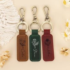 three leather key chains with flowers on them