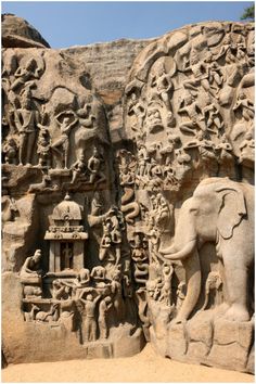 an intricately carved stone wall with elephants and people