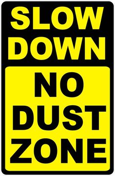 a yellow and black sign that says slow down no dust zone