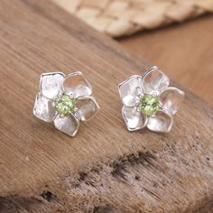 Many cultures associate peridot stones with prosperity and good fortune, as their green tone brings to mind Earth's abundance. Using these gems as the centerpiece, Balinese artisan Wayan Lasti crafts a pair of sterling silver stud earrings in a sweet flower shape. The accessory features a high polish finish for an elegant accent. Green Spiritual Gemstones For Gifts, Spiritual Green Gemstones For Gifts, Spiritual Green Gemstones For Gifting, Unique Peridot Jewelry For May Birthstone, Green Gemstones For May Birthstone Gift, Handmade Peridot Jewelry For May Birthstone, Green Peridot Gemstones As Birthstones, Green Peridot Birthstone Gemstones, Green Peridot Gemstones For Gifts