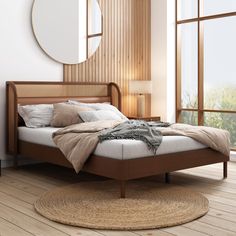 a bed sitting on top of a wooden floor next to a round mirror above it