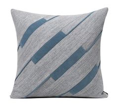 a gray and blue striped pillow on a white background