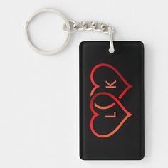 a black square keychain with a red design on it