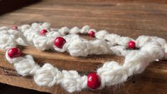 a close up of a piece of wood with yarn on it and beads in the shape of hearts