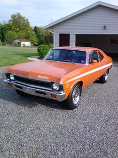 an orange car parked in front of a garage