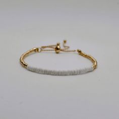 Gold Beaded bracelet, with white heishi beads centered on an adjustable gold cord.  Made very sturdy and adjustable to fit all wrist sizes. Gold Beaded Bracelet, Gold Bead Bracelets, Heishi Beads, Adjustable Bracelet, Gold Beads, Beaded Bracelet, Jewelry Bracelets, Beaded Bracelets, Bracelet