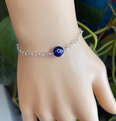 a bracelet with an evil eye on it is sitting on a mannequin's hand