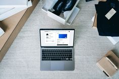 an open laptop computer sitting on top of a table next to boxes and other items