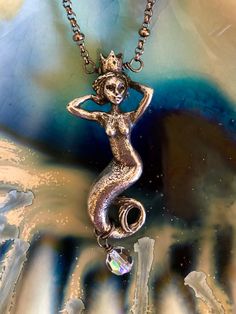 "Known as the Goddess of the Sea this lovely mystical Green Girl Studio pewter mermaid queen is accented with Swarovski crystal on sparkling gunmetal satellite chain. Enchanting mermaid charm with crown is 3D with amazing detail on all sides. Measures 42mm in length. Sparkling 6mm Swarovski Crystal AB round bead is wire wrapped at the bottom. Total drop with crystal is 1 7/8\". Pendant is wire wrapped onto pretty 18\" gunmetal rolo chain with lots of sparkle. Closes with lobster claw clasp and 1 Bohemian Mermaid Necklace For Gifts, Bohemian Mermaid Necklace Gift, Paris Charm Bracelet, Mermaid Queen, Goddess Of The Sea, Mermaid Pendant, Girl Necklace, Silver Mermaid, Mermaid Gifts