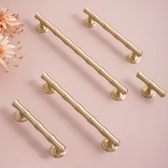 brass handles and pulls on a pink background with flowers in the foreground, from top to bottom