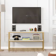 a flat screen tv sitting on top of a wooden shelf next to a white wall