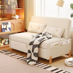 a living room with a white couch and black and white blanket on top of it